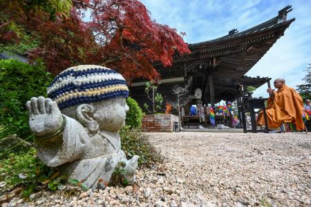 2023年5月14日に撮影されたこの写真には、広島の近くにある宮島の仏教寺院大聖院にて、数千羽の折り鶴のお焚き上げを進めている三松庸裕氏(右)が写っている。(AFP)