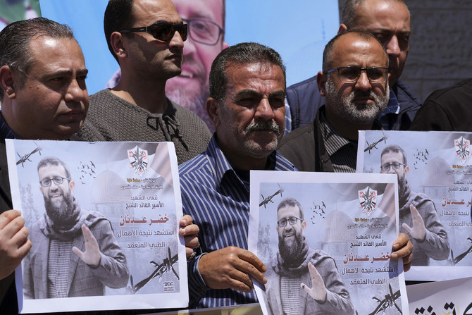 2023年5月2日、約3カ月のハンガーストライキの末にイスラエルの刑務所で死亡した過激派組織「イスラム聖戦」の指導者、ハデル・アドナン氏の写真を手にするパレスチナ人。(AP通信)