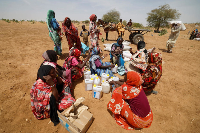2023年5月9日、チャドのKoufrounのスーダンとチャドの国境付近において、平等に分け合うべき世界食糧計画（WFP）からの食料配給を受け取ってから座る、国内の暴力を逃れてきたスーダン難民たち。（ロイター）