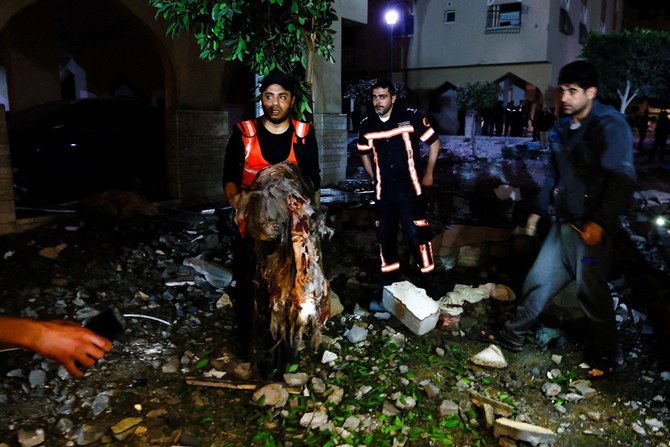 ガザ地区南部のハン・ユーニスで、イスラエルの攻撃で死亡した人々の遺体を探すパレスチナ人。（ロイター）