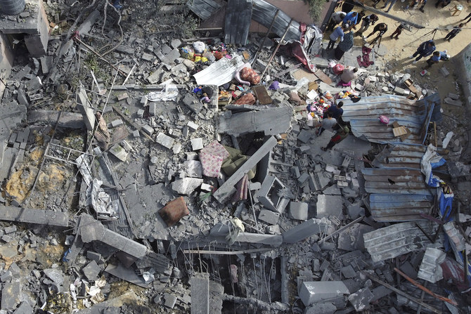 イスラエルの空爆を受けた建物の瓦礫をかき分ける人々。ガザ地区北部のベイト・ハヌン。(AFP)