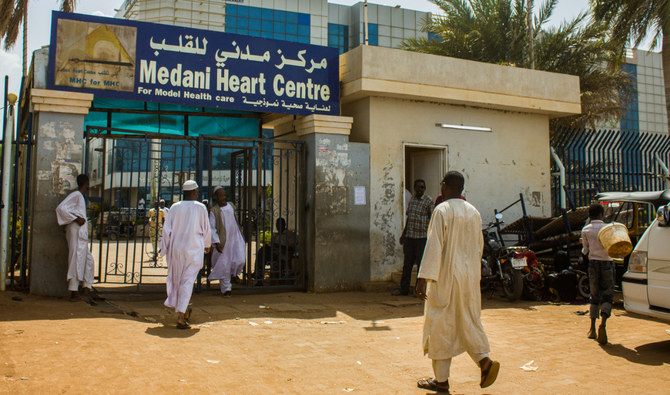 スーダン中東部ジャジーラ州の州都ワドメダニのメダニ心臓センター病院の入口に向かって歩く人々。2023年5月25日。（AFP）