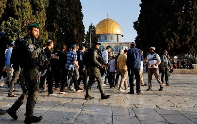 エルサレムの古都にて、アル・アクサ構内の入植者の横を歩くイスラエルの治安部隊員ら。（ファイル/ロイター）