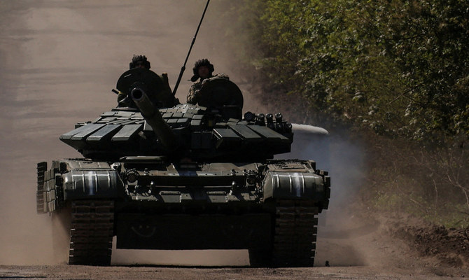 ロシアによるウクライナ侵攻のさなか、戦車に乗って前線の町バフムトに向かうウクライナの軍人たち。（ロイター）