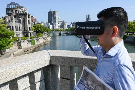 1945年の原爆投下前、投下時、投下後の街を体験できるVR(仮想現実)ツアーを提供する企業に勤める山口洋氏が、広島の爆心地近くにあった広島公園レストハウスで唯一の生存者について話す様子。2023年5月15日撮影 (AFP)