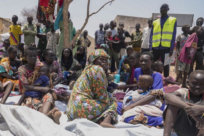 スーダンから逃れ、南スーダンのレンクのトランジットセンターの栄養クリニックの外に座っている南スーダン人たち。（AP通信）
