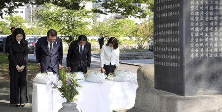 2023年5月21日（日）、日本・広島の平和記念公園近くにある「韓国原爆犠牲者慰霊碑」に、一礼して哀悼する韓国の尹錫悦大統領（中央）と金建希夫人、日本の岸田文雄首相と岸田裕子夫人。 (AP)