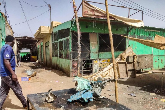 スーダンの首都ハルツーム南部のスーク・シッタ（6番市場）で、破損した店の前を歩く男性（2023年6月1日撮影）（AFP）