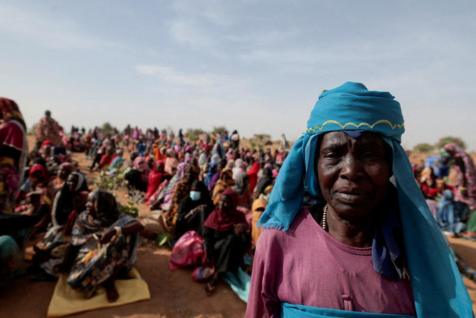 チャドに避難するスーダン難民のハリメ・アダム・ムーサ氏が、他の難民に混じって国連世界食糧計画（WTP）が支給する食料配給を受け取っている。（Reuters）