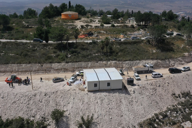 イスラエルの前哨入植地ホメシュに設置中の移動式建物の周辺の人々の空撮画像。ホメシュは、占領下のヨルダン川西岸地区内のブルカというパレスチナ人村の近隣にある。2023年5月29日。（写真：メナヘム・カハナ / AFP）