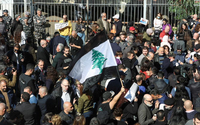 2023年1月26日、ベイルートの司法宮殿の前で、レバノンの最高検察官に対する2020年のベイルート港爆発事故の被害者家族のための抗議中に、白黒のレバノン国旗を掲げるデモ参加者。（ロイター/ファイル）
