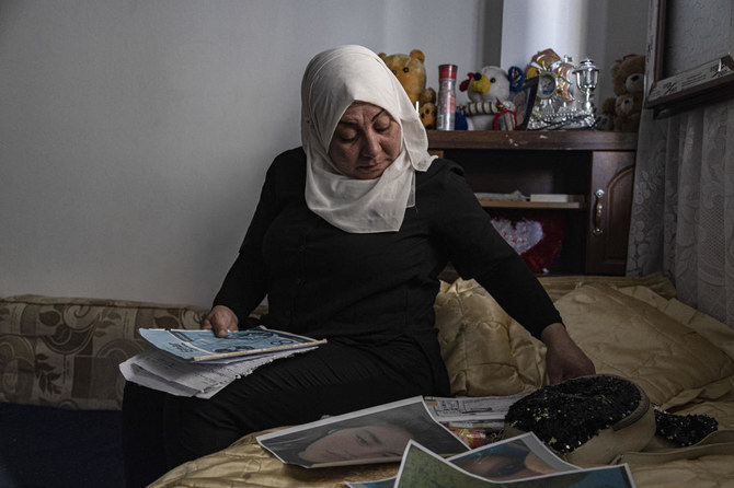 13歳のペイヤル・アキルさんの母親ハムリン・アルージさん、シリアのカーミシュリーにある自宅で娘の写真に目を通す。（AP）