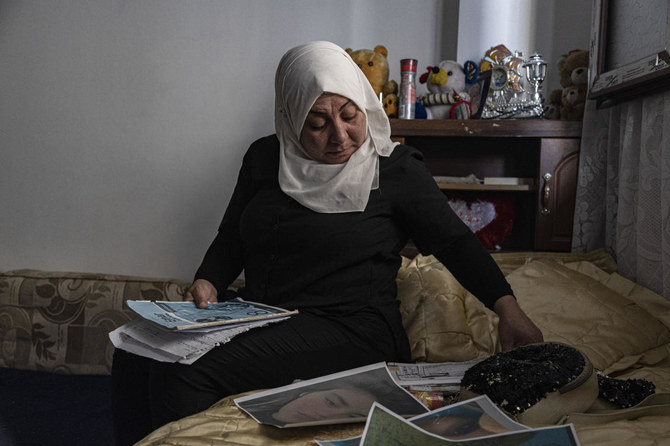 13歳のペイヤル・アキルさんの母親ハムリン・アルージさん、シリアのカーミシュリーにある自宅で娘の写真に目を通す。(AP)