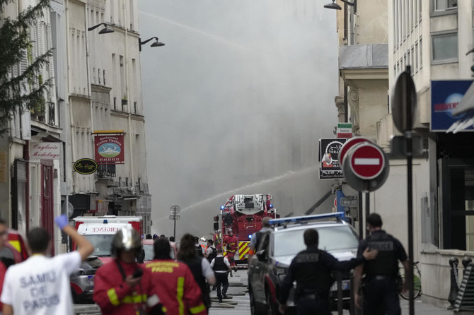 2023年6月21日、パリで放水銃を使って消火活動を行う消防士たち。パリの左岸で発生した火災で、ドーム形のパンテオンのモニュメントを覆うように煙が上がり、消防士たちは近隣の建物から避難するよう呼びかけている。（AP）