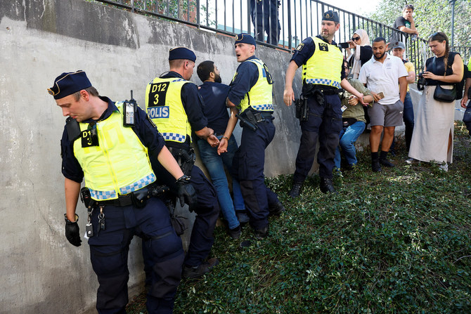 6月28日、スウェーデンのストックホルムにあるストックホルム中央モスクで、デモ参加者がコーランを燃やし（写真には写っていない）、集まった人々の反応を受けて介入する警察官。（ロイター）