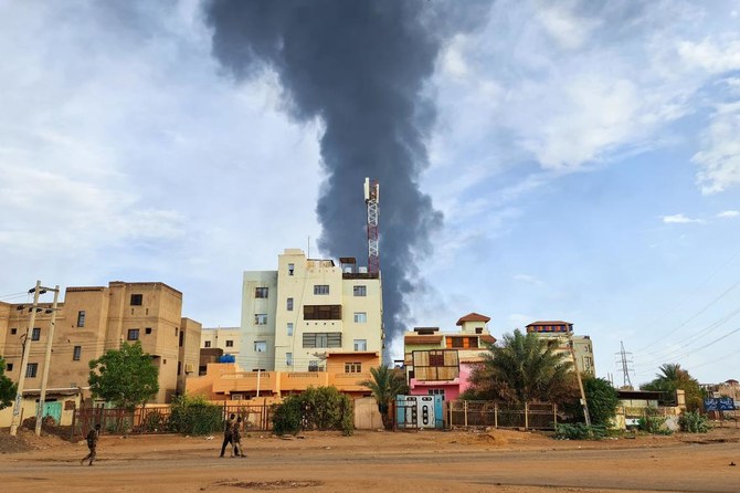 ハルツームで戦闘が続く中、建物の背後で黒煙が立ち上る。2023年6月9日(AFP)