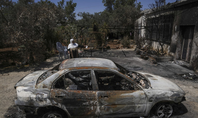 ヨルダン川西岸地区の村トゥルムス・アヤで、ユダヤ人入植者らに放火され数日経った自分の家の外で座り込む女性。2023年6月24日（AP）