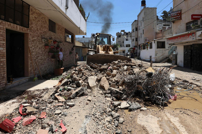 パレスチナ人12人とイスラエル軍兵士1人が殺害された、ヨルダン側西岸地区のジェニンでの2日間に及ぶイスラエルの軍事行動の後、難民キャンプの道路に沿って瓦礫を撤去するブルドーザー。2023年7月6日。（AFP）