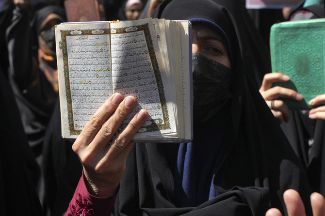スウェーデンでイスラム教の聖典コーランが燃やされた事件に抗議するデモの最中、コーランを掲げるイラン人参加者ら。2023年6月30日、イランのテヘランのスウェーデン大使館前。（AP）