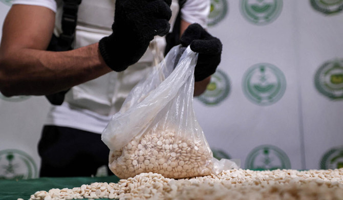ジェッダでの特殊作戦で押収したカプタゴン錠剤の入ったバッグを空にするサウジアラビア内務省の麻薬取締局員。（AFP資料写真）