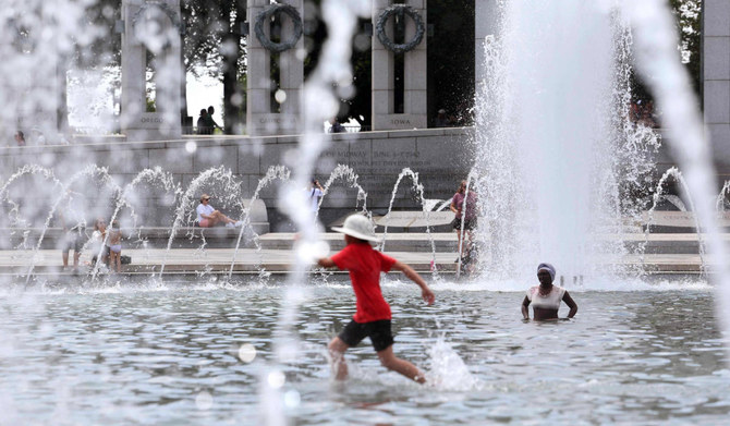 2023年7月3日、ワシントンDCにある第二次世界大戦記念碑の噴水で暑さをしのぐ訪問者や観光客。（AFP通信）