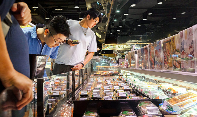 店頭に並ぶ日本食を眺める客ら。香港は量的には日本食品への依存度は高くないが、住民らは大いに日本食を好む。（AP）