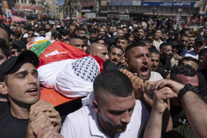 バドル・アル・マサリさん（19）の葬儀で、彼の遺体を運びながらイスラエルを非難するスローガンを唱える参列者たち。2023年7月20日、ヨルダン川西岸地区の都市ナブルス。パレスチナ保健省によると、イスラエル軍は同日に同地区の聖廟付近で彼を射殺した。この地域で続く暴力の連鎖におけるまた新たな流血となった。（AP）