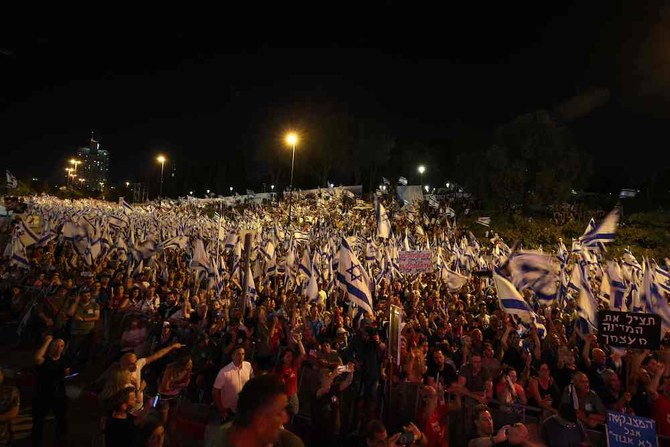 政府による司法改革案の国会での採決を前に抗議のためにテルアビブから始まった数日間の行進のさなか、イスラエル国旗を振りながら進むデモ隊。2023年7月22日、エルサレム。（AFP）