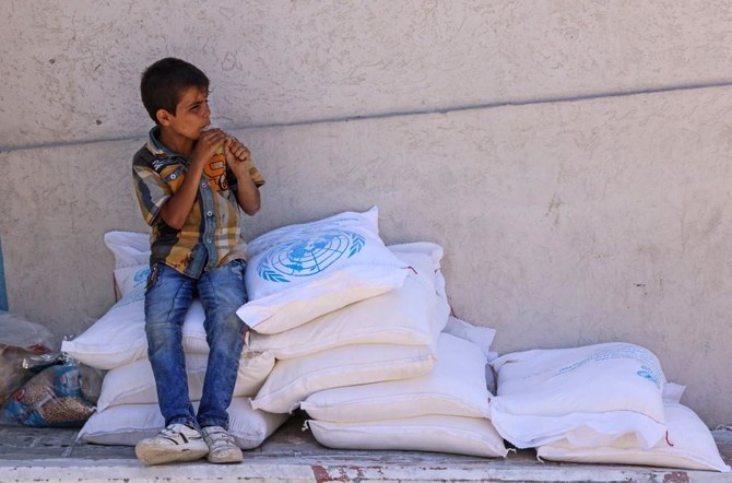 ガザ地区南部のラファにあるUNRWAの倉庫から食糧を受け取るパレスチナ人の少年。（ファイル/AFP）