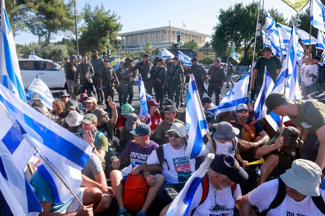 2023年7月24日、数ヶ月間続く政府の司法改革案に対する抗議の最中、イスラエルの警備隊員が、エルサレムの議会（クネセト）入口を封鎖するデモ隊を排除するために出動。（AFP）