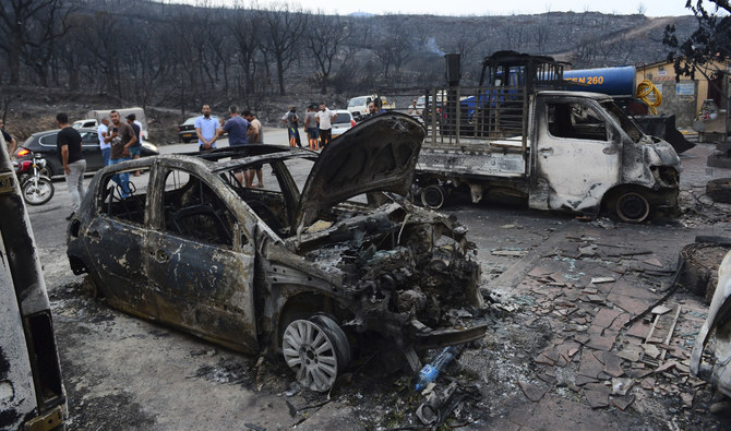 猛威を振るった山火事の後、黒焦げになった車両を調査する人々、アルジェリアのアルジェから100キロメートルの場所にあるブーリアにて、2023年7月24日月曜日。(AP)