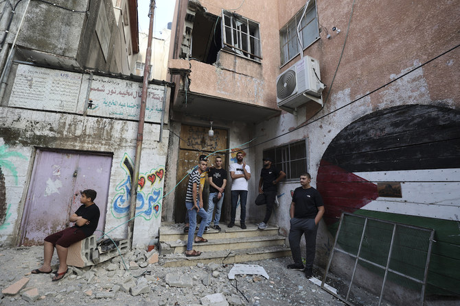 ヌール・シャムス難民キャンプで、指名手配中のパレスチナ人を捜索するためイスラエル軍が突入した後、被害状況を確認する住民たち。 (File/AFP)