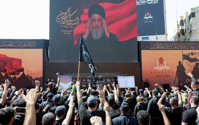 2023年7月29日、レバノンのベイルート南の郊外で開かれたアーシュラーを祝う宗教儀式で、スクリーン越しに支持者に演説するレバノンのヒズボラの指導者ハッサン・ナスラッラー師。（ロイター）