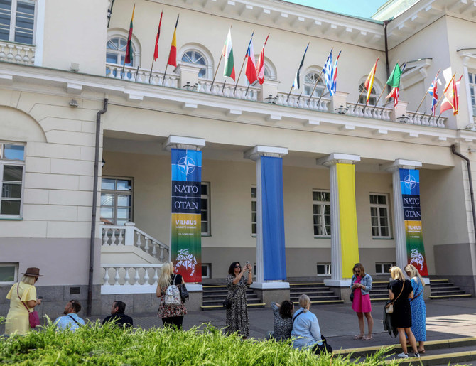 7月11日から12日にかけて開催されるNATO首脳会議を数日後に控え、リトアニアのヴィリニュスにある大統領府の前に立つ訪問者たち。(AFP＝時事）