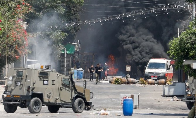 2023年7月3日、イスラエル占領下のヨルダン川西岸ジェニンでのイスラエルの軍事作戦中、イスラエル軍との衝突中に逃げるパレスチナ人。（ロイター）