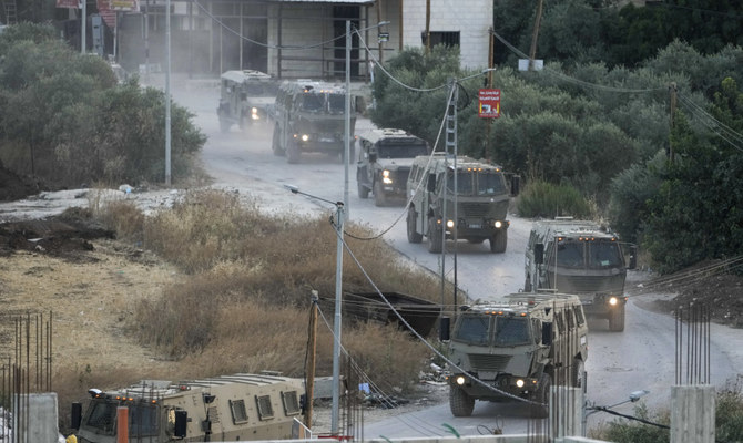 2023年7月4日、占領下のヨルダン川西岸のジェニン難民キャンプを襲撃する軍用車両の車列（AP）