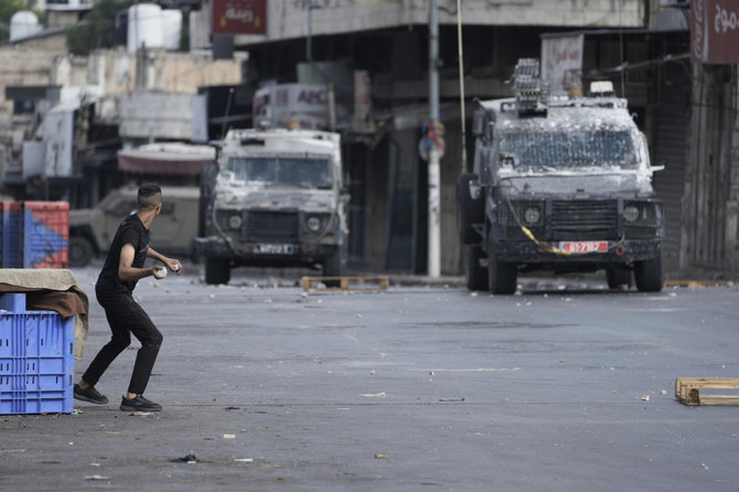 ヨルダン川西岸地区のナブルスで、軍事作戦中にイスラエル治安部隊と衝突するパレスチナ人。2023年7月7日（AP）