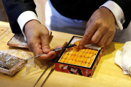 2023年7月25日、中国・北京でロイター通信のインタビューに応じ、中国国内で調達したウニを使った寿司を作る日本料理レストラン「東也」オーナーの谷岡一幸氏。（ロイター通信）