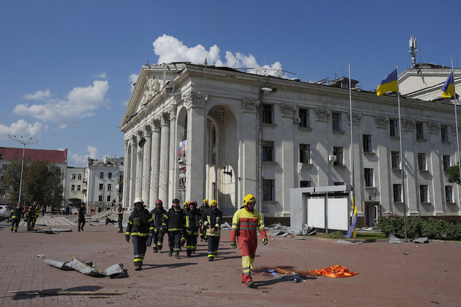 2023年8月19日土曜、ウクライナのチェルニヒウで、ロシアの攻撃により破損した、タラス・シェフチェンコ・チェルニヒウ地方音楽・演劇劇場の傍を歩く消防士たち。(AP)
