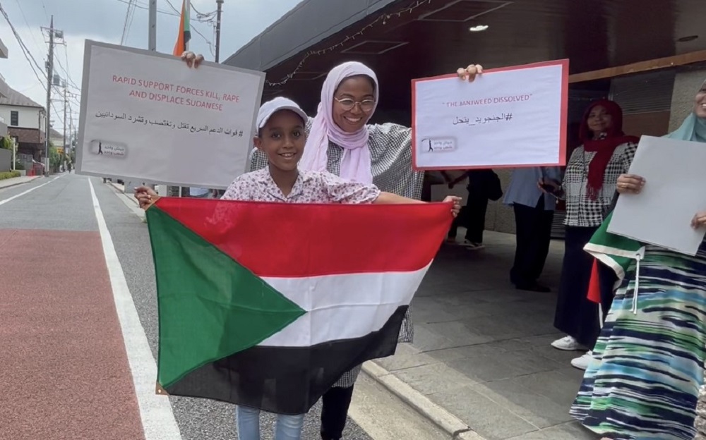 東京のスーダン大使館前で日曜日、少数の人々がRSF（即応支援部隊）の軍事蜂起を非難し、スーダン軍への支援を訴えるデモを行った。(ANJ/ Elina Pernin)