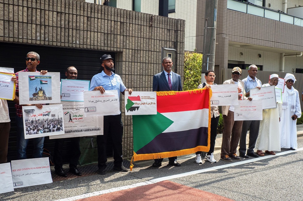 東京のスーダン大使館前で日曜日、少数の人々がRSF（即応支援部隊）の軍事蜂起を非難し、スーダン軍への支援を訴えるデモを行った。(ANJ/ Elina Pernin)