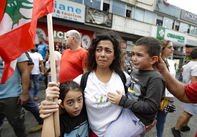 政府が緊急経済救済計画を採用したにもかかわらず開かれた、新たな指導者を要求する集会で、感情を表に出すレバノンの母親とその子供たち。2019年10月23日、ベイルート。（AFP）