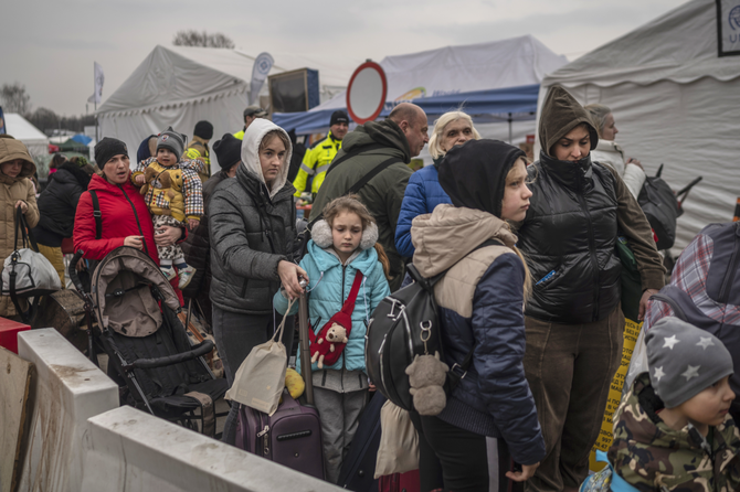 2022年3月29日、ロシアによるウクライナ侵攻から34日目、ポーランド南東部のウクライナとポーランドの国境を越えた後、メディカの国境検問所でさらなる移送を待つウクライナ人難民たちの列。（AFP/資料写真）