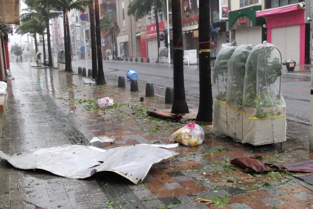 台風6号による強風が那覇市を襲い、繁華街の通りに瓦礫が散乱している。（AFP）