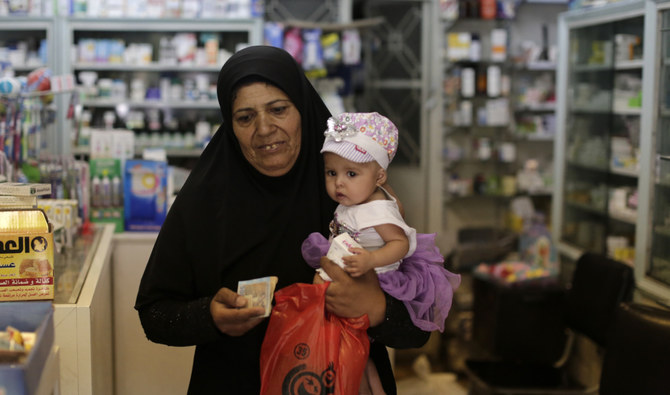 シリア・ダマスカスで薬を購入後、薬局を出る女性（2019年7月24日）。ダマスカスの薬局組合のトップは8日、シリアポンドのレートが最低を更新する中、シリア政府が薬価の50%引き上げを決定したと述べた。（AP/資料写真）