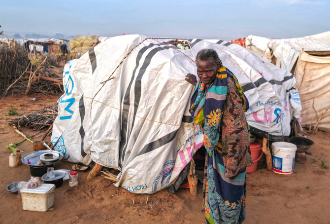 スーダンのダルフール地方のジュナイナの紛争から逃れてきたスーダン人女性、カディジャ・イッサ・ハミスさん（90）。仮設の寝泊まり場所の外を歩いて周りを見回す。チャドのアドレ。（ロイター）