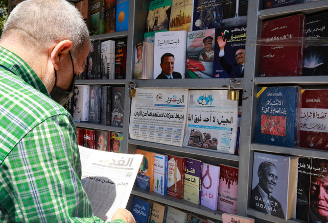 2021年4月4日、アンマンの売店前で地方紙を読むヨルダン人男性（AFP ファイル)