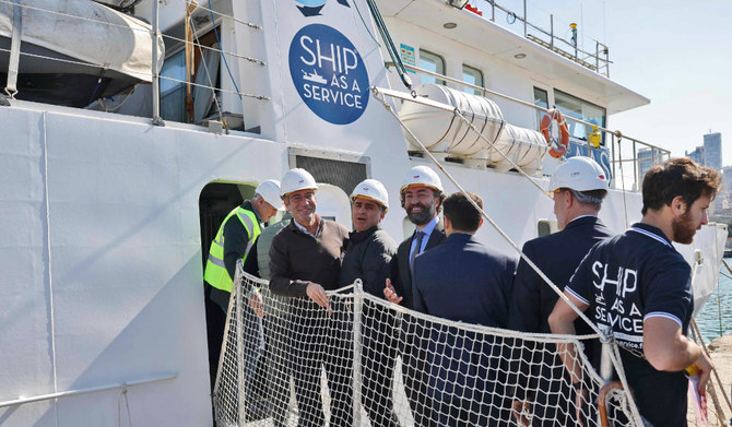 2023年2月17日、ベイルート港に停泊中の海洋調査船「JamusII」の前に立つ関係者たち。(AFP＝時事）