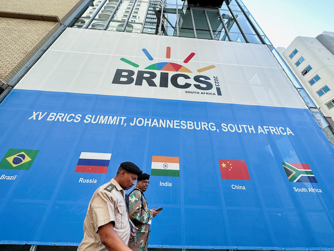 2023年8月19日、南アフリカ・ヨハネスブルグで開催されるBRICS首脳会議の会場となるサントン・コンベンション・センターを通り過ぎる人々。(REUTERS)