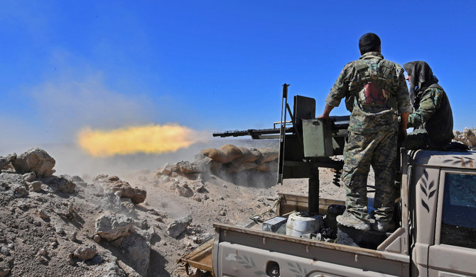 ダーイシュの残党が抵抗する最後の地、シリア東部ダイル・ザウル県にある辺境の街バグーズに向けて、トラックに積んだ銃を発射するシリア民主軍（SDF）の戦闘員。（AFPファイル写真)